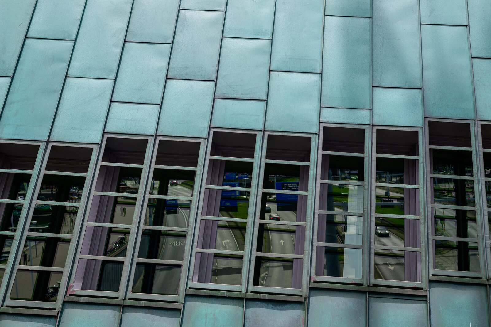 Teal Panels Copper-clad slope of the NEMO Science Museum in Amsterdam with city street reflections.