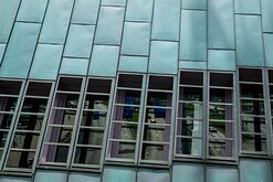 Teal Panels Copper-clad slope of the NEMO Science Museum in Amsterdam with city street reflections.