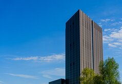 Vertical Giant Tall modern office tower rises against a clear blue Amsterdam sky.
