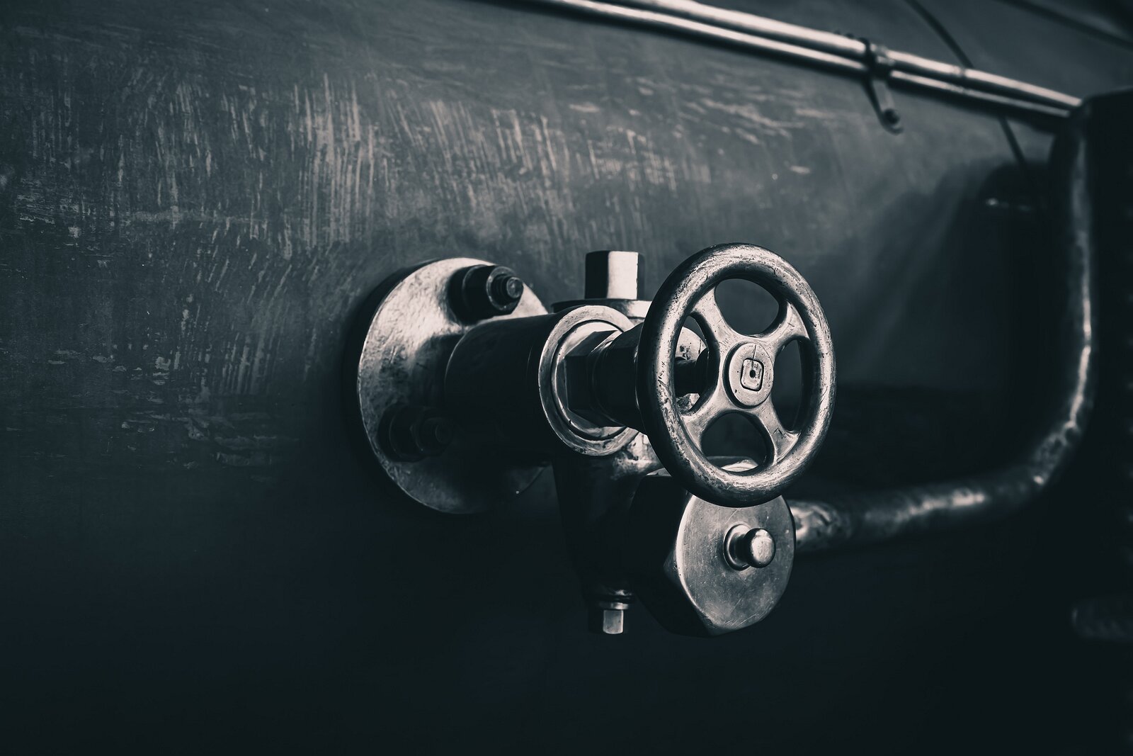 Iron Throttle Metal valve wheel mounted on the side of a steam-locomotive boiler.