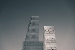 Stepped Towers Three stepped high-rise buildings rise against a muted grey sky.