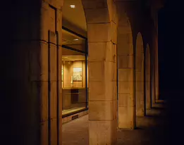 Amber Silence A fine art night photograph capturing the tranquil beauty of a stone arcade bathed in warm light. The soft glow and rhythmic columns evoke stillness, elegance,...