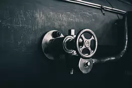 Iron Throttle Metal valve wheel mounted on the side of a steam-locomotive boiler.