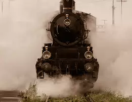 Vintage Power A vintage steam locomotive pushes forward through thick clouds of white steam.