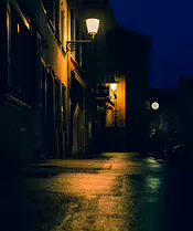 The Lantern Path A narrow street glows under warm lanterns, their light tracing the old facades and wet cobblestones. The deep blue sky and distant clock hint at a quiet city...
