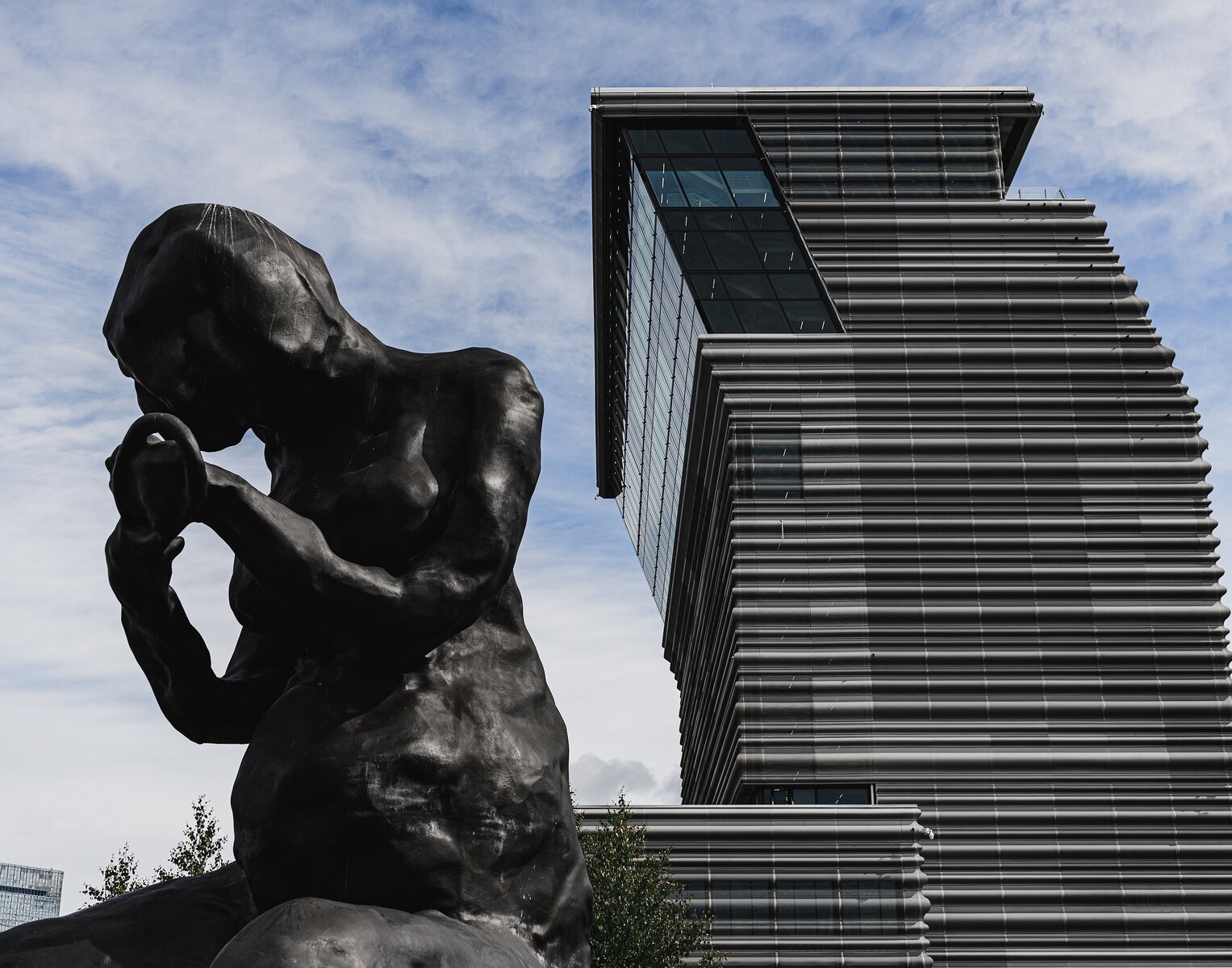 Contrast Forms Bronze sculpture The Mother by Tracey Emin kneels before the leaning tower of the MUNCH Museum in Oslo.