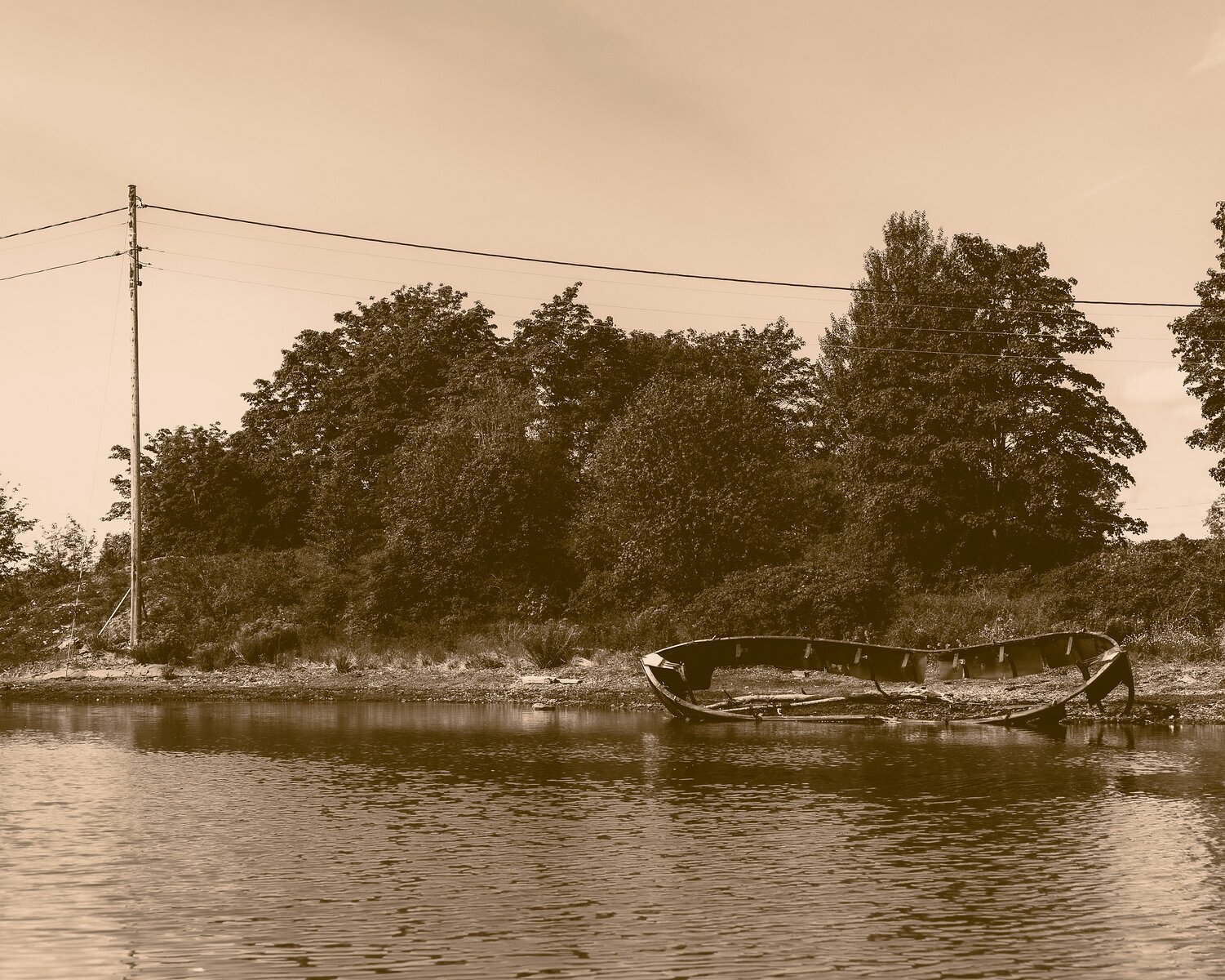 Silent Hull Sepia-toned remains of a wooden boat lie stranded on a calm Oslo inlet.