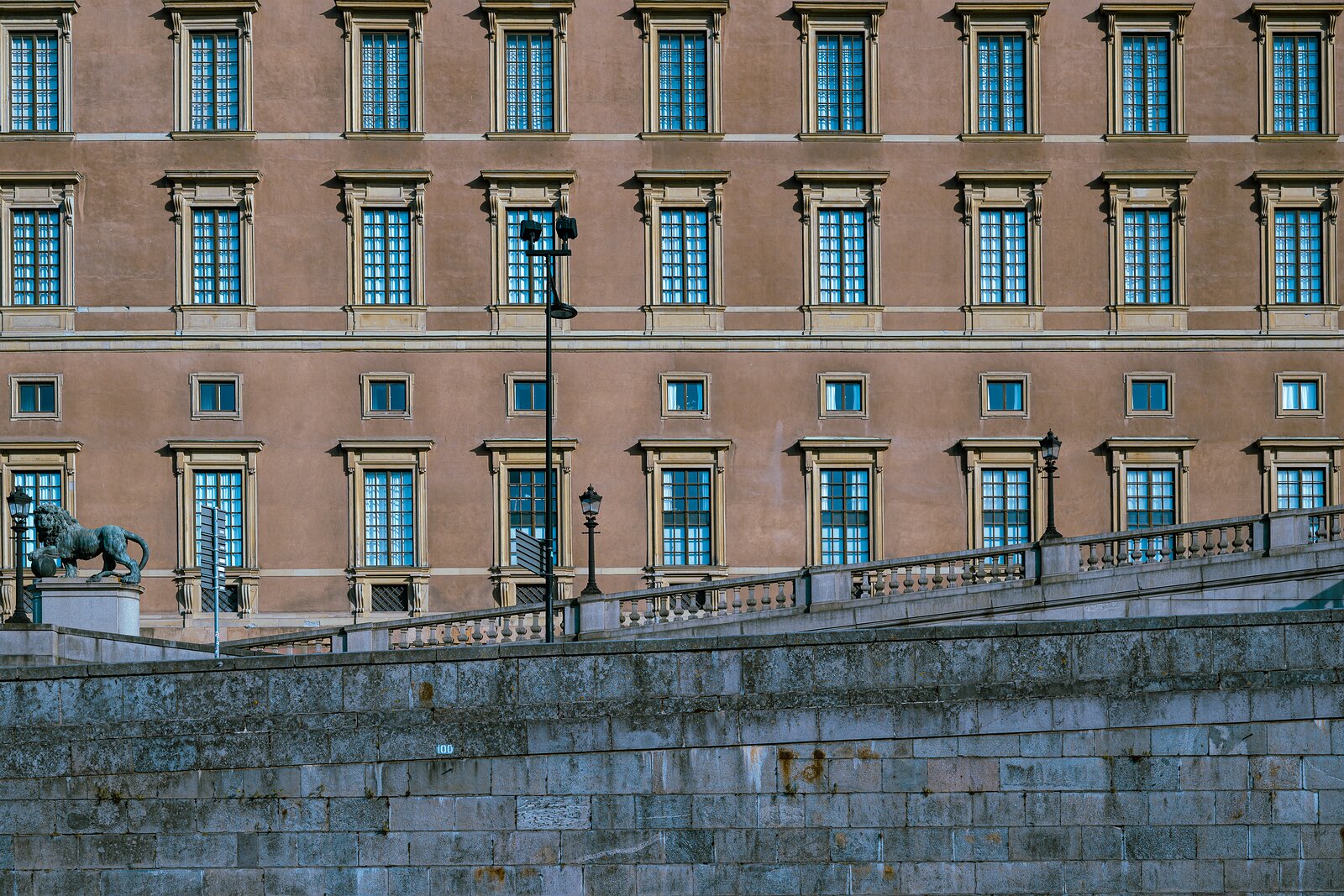Royal Walls Exterior of Stockholm’s Royal Palace with rows of identical windows and a stone-lion balustrade in front.