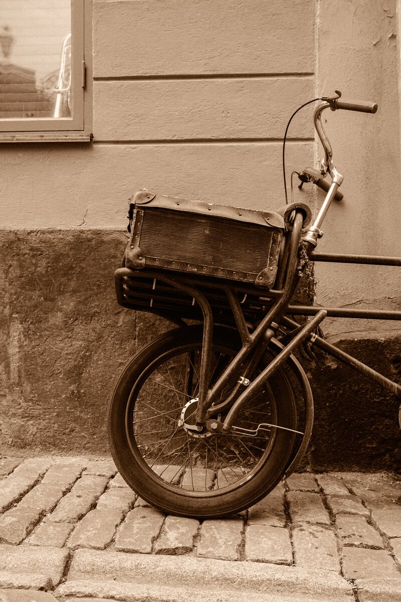 Rustic Wheel A weathered cargo bicycle rests against a stucco wall on a cobblestone lane in Stockholm’s Old Town.