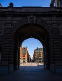 Stone Gateway The granite arch of Sweden’s Parliament (Riksdagshuset) frames a sunlit city street beyond.