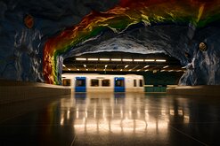 Color Cavern A blur of a passing train slides beneath the rainbow-painted cave ceiling of Stockholm’s Stadion metro station.