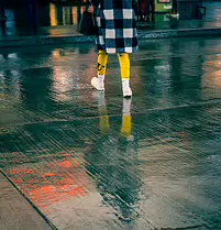 Yellow Echo A splash of yellow cuts across rain-soaked pavement, mirrored in a shifting pool of neon reflections.