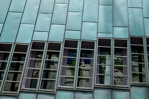 Teal Panels Copper-clad slope of the NEMO Science Museum in Amsterdam with city street reflections.