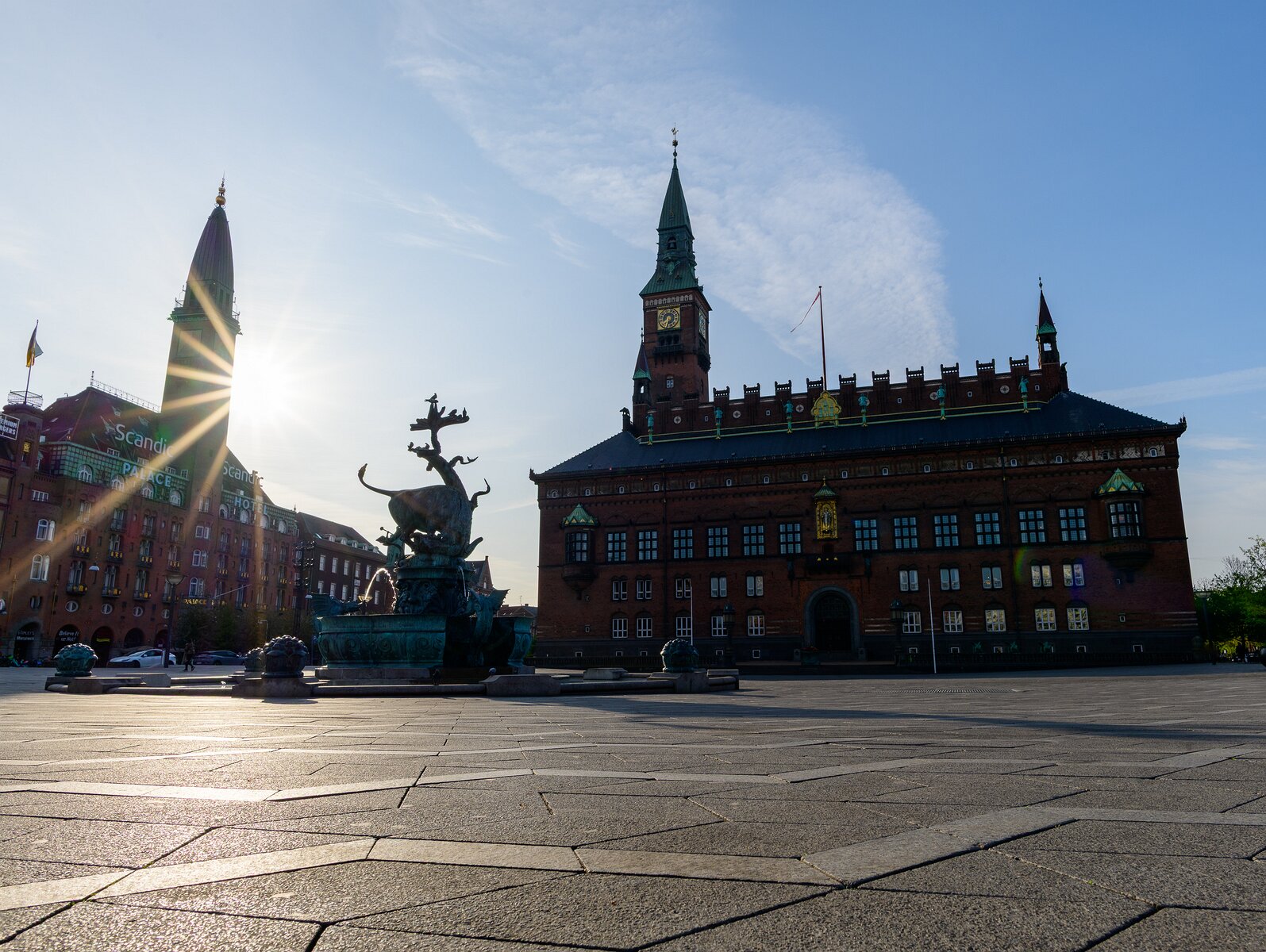 Sunburst Spire Dragon Fountain and Copenhagen City Hall stand prominently on Rådhuspladsen under a low sun.