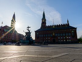 Sunburst Spire Dragon Fountain and Copenhagen City Hall stand prominently on Rådhuspladsen under a low sun.