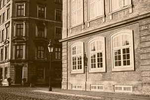 Vintage Streetscape Sepia street scene on Ny Vestergade with a vintage lamp casting shadow against brick facades in Copenhagen.