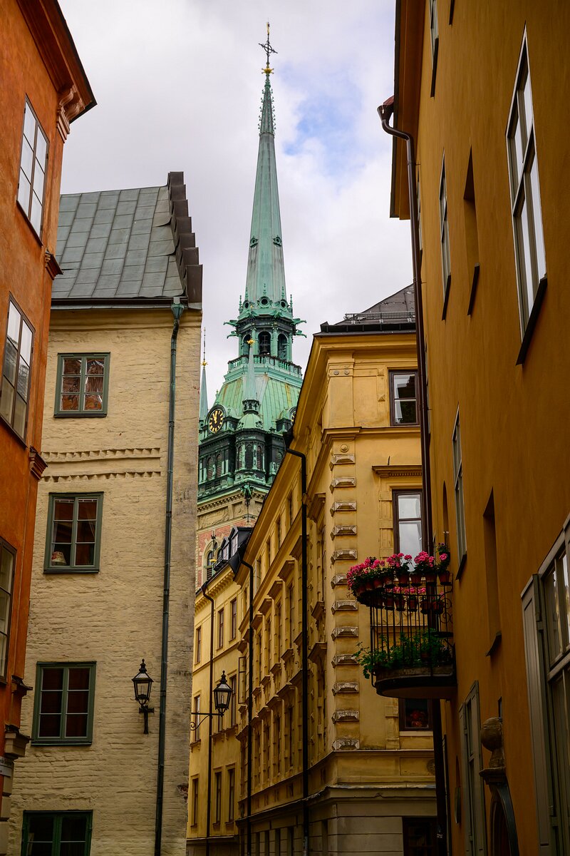 Spire Peek The slender green spire of the German Church (Tyska Kyrkan) rises above tight, pastel alleyways in Gamla Stan.