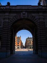 Stone Gateway The granite arch of Sweden’s Parliament (Riksdagshuset) frames a sunlit city street beyond.
