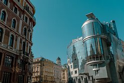Mirror Contrast Glass-clad Haas Haus and neighbouring historic façades meet under a clear sky at a central Vienna intersection.