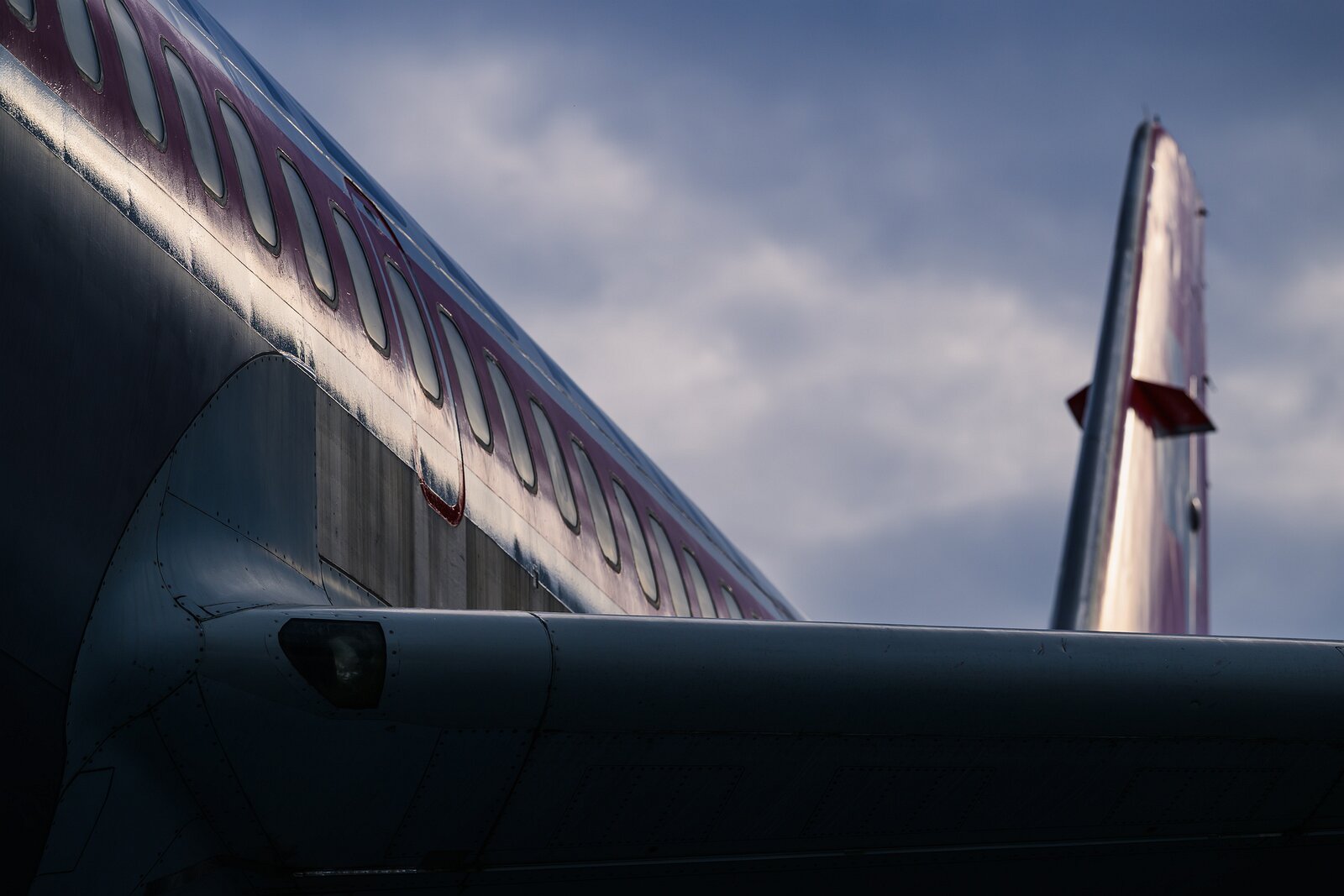Winged Geometry A rear view of a commercial jet reveals clean metallic lines under a moody sky.